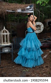 Fashion Image Of Beautiful Asian Indian Woman Wearing Blue Gown In A Junk Yard. 