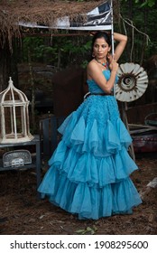 Fashion Image Of Beautiful Asian Indian Woman Wearing Blue Gown In A Junk Yard. 