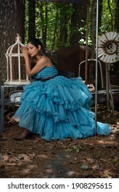 Fashion Image Of Beautiful Asian Indian Woman Wearing Blue Gown In A Junk Yard. 