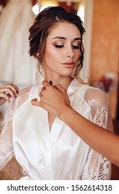 Fashion Interior Photo Of Beautiful Woman With Dark Hair Posing In Silk Robe In The Morning Of Her Wedding Day, Finishing Preparations