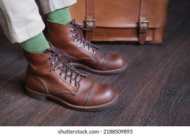 Fashion Leather Briefcase And Men's Stylish Brown Work Boots Close Up On Wooden Floor