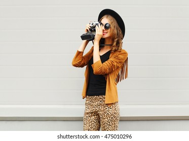 Fashion Look, Pretty Cool Young Woman Model With Retro Film Camera Wearing A Elegant Hat, Brown Jacket, In Profile Outdoors Over City Grey Background