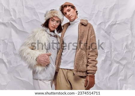 fashion lookbook concept, interracial models in winter attire posing on white textured background