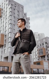 Fashion Man Holding Black Messenger Bag In The Autumn City