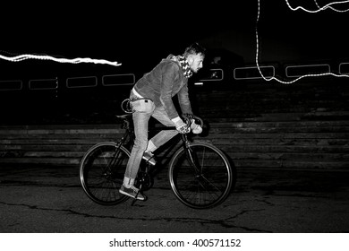 Fashion Man On The Fixed Gear Bike Rides Around The City At Night. Black And White