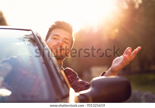 Fashion man\
sitting in luxury cabriolet car\
outdoors
