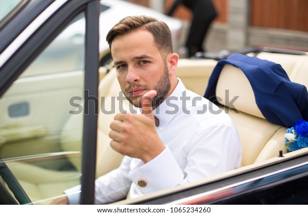 Fashion man sitting in luxury retro cabriolet
car outdoors