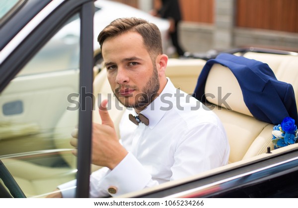 Fashion man sitting in luxury retro cabriolet\
car outdoors