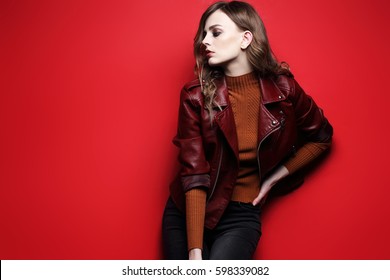Fashion Model  Beautiful Young Woman. Leather Jacket, Studio Shot, Red Background