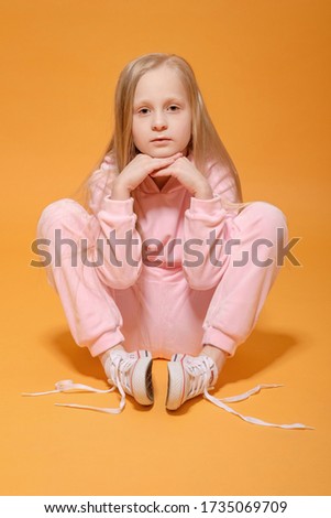 fashion model blonde girl in pink clothes on yellow background