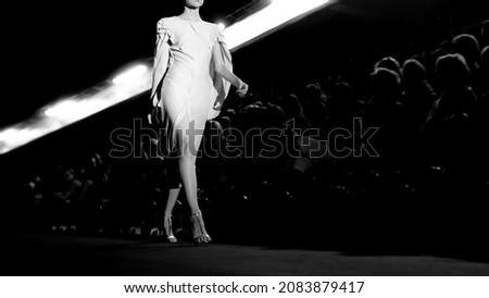 A fashion model at a catwalk during a fashion show or fashion week.