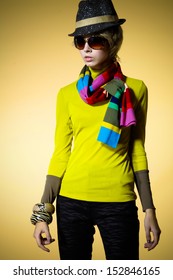 fashion model in fashion dress wearing sunglasses with scarf - beige background