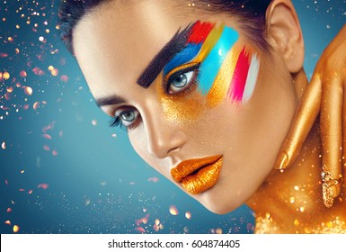 Fashion Model Girl with colored face painted. Beauty fashion art portrait of beautiful woman with colorful abstract makeup. Vivid paint make-up, bright colors. Vogue style lady , Multicolor design.
