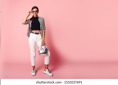 Fashion Model Girl Full Length Portrait Isolated On Pink Background. Beauty Stylish Brunette Woman Posing In Fashionable Clothes In Studio. Casual Style, Beauty Accessories. High Fashion Urban Style