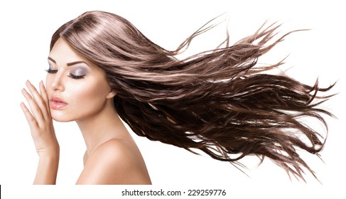 Fashion Model Girl Portrait With Long Blowing Hair. Glamour Beautiful Woman With Healthy And Beauty Brown Hair Isolated On White Background Touching Her Face. Skin Care And Beautiful Hair Concept