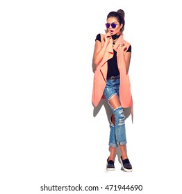 Fashion Model girl wearing sunglasses isolated over white background. Beauty stylish brunette woman posing in fashionable clothes in studio. Casual style, beauty accessories. High fashion urban style
