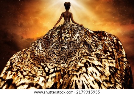 Fashion Model in Golden flying Dress looking away at Light. Afro Style Woman in Gold Long Gown fluttering on Wind rear view. Exotic Dancer with Silk Fabric over Art Fantasy Background