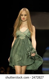 Fashion Model In Green Toned Dress Walking Down The Runway