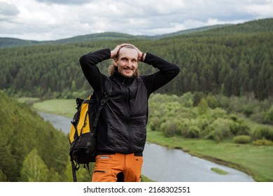 A Fashion Model Guy Poses Standing High In The Mountains, A Hairy Man Touching His Head With His Hands, A Man Smoothing His Hair Back, A Summer Trip Alone. High Quality Photo