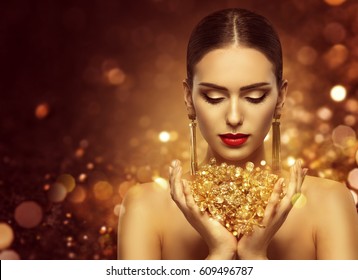 Fashion Model Holding Gold Jewelry in Hands, Woman Golden Beauty, Beautiful Girl Makeup and Luxury Jewellery