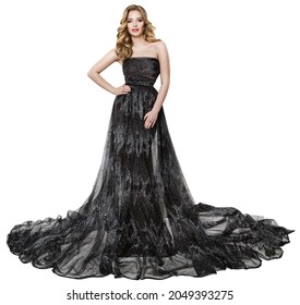 Fashion Model In Long Black Dress. Stylish Woman With Perfect Curly Hairstyle And Make Up In Sparkling Holiday Luxury Gown Over Isolated White