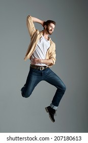 Fashion Model Man With Hipster Beard Jumping And Having Fun In Studio