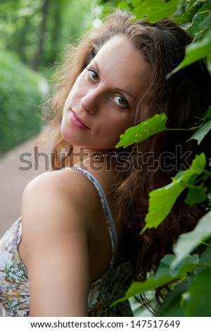 fashion model on a background of foliage in the summer in the heat