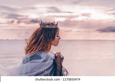 fashion model portrait. young pretty woman with crown outdoors at sunset