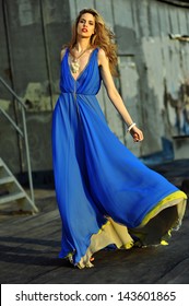 Fashion Model Posing Sexy, Wearing Long Blue Evening Dress On Rooftop Location