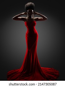 Fashion Model Silhouette In Red Long Dress. Stylish Female Portrait In Contour Light Over Black Background. African Woman Hidden Face In Shadow Backlight. Mysterious Women Body Shape Fine Art Portrait