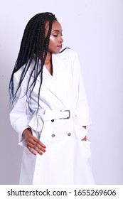 Fashion Model Style. Fashionable Woman In Stylish Clothes Posing On White Background In Studio. Beautiful African  Sexy Girl Wearing White Coat. High Resolution