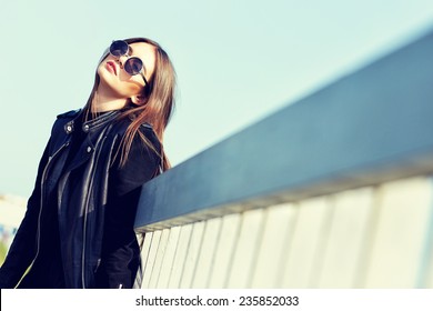 Fashion Model In Sunglasses And Black Leather Jacket Posing Outdoor