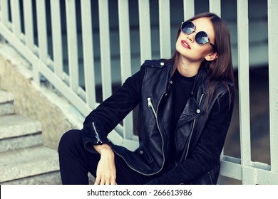 Fashion Model In Sunglasses And Black Leather Jacket Posing Outdoor