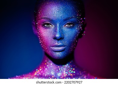 Fashion model woman in blue bright sparkles   neon lights posing in studio   Portrait beautiful young woman  Art design colorful glitter glowing make up