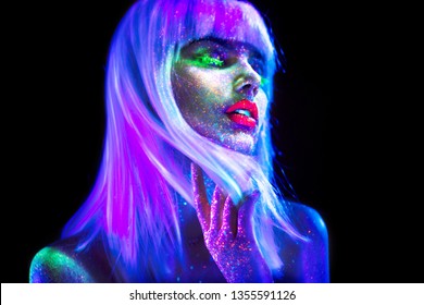 Fashion model woman dancing in neon light, disco night club. Beautiful dancer model girl colorful bright fluorescent make-up, painted skin, Body Art design of disco. Ultraviolet, UV, colorful make up
