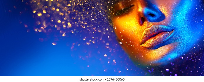 Fashion model woman skin face in bright sparkles, colorful neon lights, beautiful sexy girl lips, mouth. Trendy glowing gold skin make-up. Art design make up. Glitter metallic shine golden blue makeup