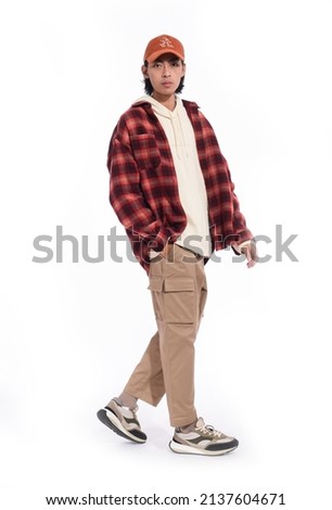 fashion model. young man with hairstyle in striped shirt ,hoodie,hat  with posing in studio on white background