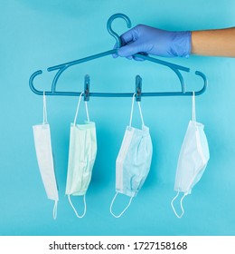 fashion outfit at pandemic time. face masks hanging on a rack over pastel blue background. - Powered by Shutterstock