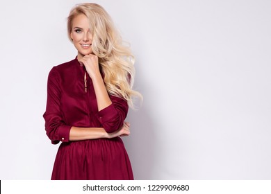 Fashion Photo Of A Beautiful Blonde Young Woman In A Pretty Dress, Red Hat Holding Handbag Posing Over White Background. Fashion Autumn Summer Photo. Hairstyle