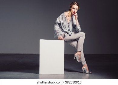 Fashion Photo Of A Beautiful Woman With Blond Nice Hairstyle Wearing Grey Top, Silver  Shoes And Jewelry.