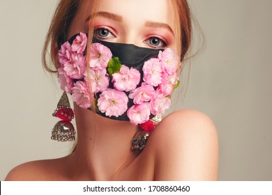 Fashion Photo Of A Girl In A Mask Of Flowers. Spring That We Cannot Breathe. Virus, Pandemic, Coronavirus, Masked Model, Beauty Model In A Mask Of Fresh Pink Flowers. Girl With A Delicate Pink Make-up