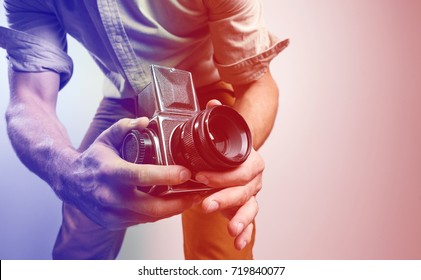 Fashion Photographer With Old Film Camera In Hand While Working In Studio. Tinted In Red And Blue.