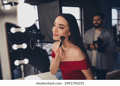 Fashion photographer working with young model woman preparing for photo session photoshoot in modern studio indoors - Powered by Shutterstock