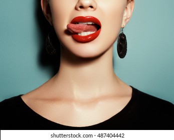 Fashion Photography. Portrait. A Model With One Earring On A Colorful Background. Natural Full Lips With Bright Lip Makeup. Red Lipstick And Lip Gloss