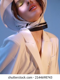 Fashion photoshoot of a young girl in blue creative light. Vogue trend photography 2022. Creative style. Skincare cosmetology. White hat and jacket