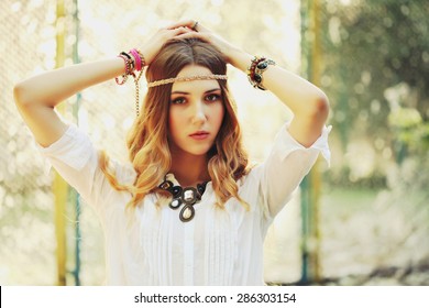 Fashion Portrait Of Beautiful Hippie Young Woman Wearing Boho Chic Clothes And Summer Hat Outdoors. Soft Warm Vintage Color Tone. Artsy Bohemian Style.