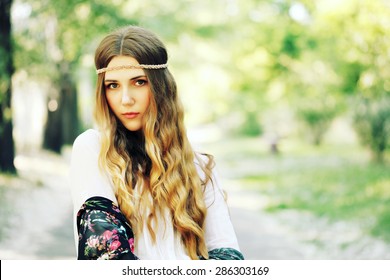 Fashion Portrait Of Beautiful Hippie Young Woman Wearing Boho Chic Clothes And Summer Hat Outdoors. Soft Warm Vintage Color Tone. Artsy Bohemian Style.