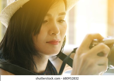 fashion portrait of beautiful woman wearing black vest and classic hat holding camera in her hand  - Shutterstock ID 680952832