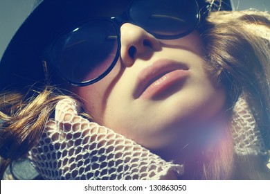 Fashion portrait of a beautiful young sexy woman wearing sunglasses