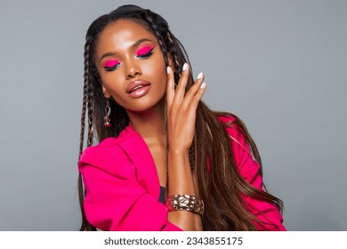 Fashion Portrait Black Woman in Pink clothes. Fashion Makeup curly hair and braids, lip gloss. Luxury Fashion model African American posing in studio, pink wall. Beautiful black woman looking down    